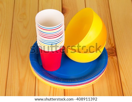Bright plastic tableware on a background of light wood.