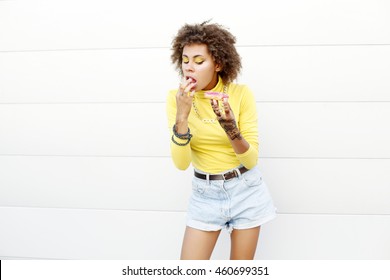 Bright Portrait Of Happy Modern Young Black Woman Eating Donuts In The City. Outdoors, Lifestyle