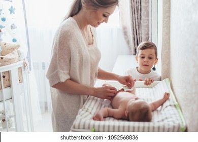 Bright portrait of a mom changing a diaper to her baby