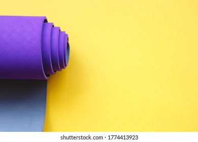 Bright Purple Yoga Mat On A Yellow Background.