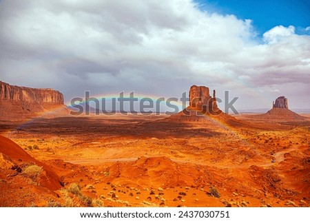 The bright rainbow all over the sky. Monument Valley is a unique geological formation in Arizona and Utah. The famous rock Mitten. USA. Navajo Indian Reservations. 