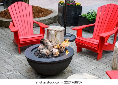 Bright red Adirondack chairs around a gas fire pit, seating in an outdoor gathering place
 - Shutterstock ID 2224968937