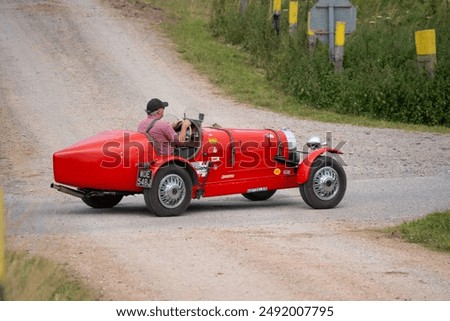 a bright red bugatti type 35B replica open-top sports car, 1971 volkswagen 1285cc underpinnings, driven through countryside