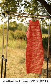 A Bright Red Dress Hangs On A Hanger.