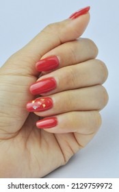 Bright Red Gel Nails On Woman Hand On White Background.