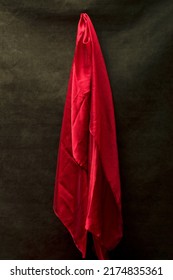 A Bright Red Handkerchief Hangs On A Green Background