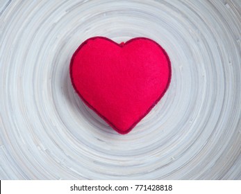 A bright red heart in the middle of wooden plate with free space around it. Ideal of holidays background, banner, backdrop, wallpaper or can be used for love concept.