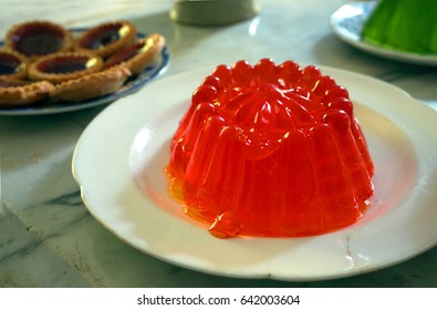 Bright Red Jelly Or Jello With Tarts And Green Jelly In The Background, On A Stone Tabletop