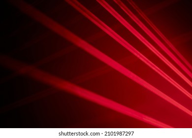Bright red neon laser lights illuminate the darkness creating lines and triangle shapes in sci-fi effect.