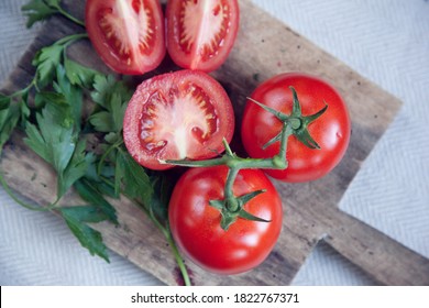 Bright Red, Ripe Juicy Pesticide Free Non GMO Organic Tomatoes On The Vine Overhead Flat Lay On A Rustic Kitchen Counter Top Chopping Board, Sliced And Cut For Weekly Meal Prep