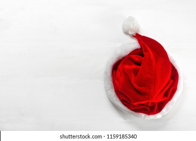 Bright Red Santa Claus Hat On Wooden Background. Top View Flat Lay Group Objects