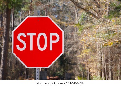 Bright red stop sign at an intersection of 2 roads
