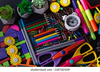 Bright School Supplies, Top View. Scissors, Clock, Pencil, Pen, Paperclip, Pin, Colorful Blocks. Stationary Pattern On Black Background