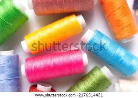 Bright sewing thread spool at white background, top view. Colorful spool with thread