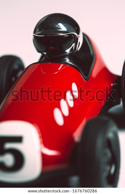 Bright silver helmet on a red toy car with number five\
painted on it