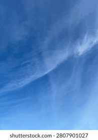 A bright sky with sparse clouds.