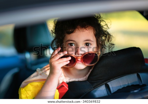 bright smile girl with glasses in the back seat of\
the car