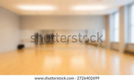 Bright and spacious empty dance studio with a wooden floor, large mirrors, ballet barres, and natural light.