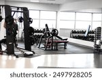 "Bright and spacious gym interior with modern fitness equipment. The well-lit environment, featuring large windows that allow natural light to flood the space, creates an inviting and energetic 