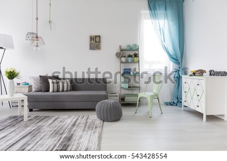 Bright spacious living room with comfortable couch and chest of drawers