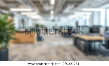 A bright and spacious open plan office interior with modern desks, chairs, and potted plants, creating a productive work environment.