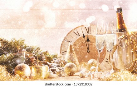 Bright Sparkling New Years Celebration Theme For Postcard With Copy Space On Shiny Background, Decorations, Couple Of Crystal Glasses Of Champagne And Vintage Clock Showing Showing Oncoming Midnight