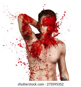 Bright splashes of red paint on a young guy. White background.