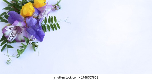 Bright Spring Flower Arrangement. Lilac Alstroemeria And Irises, As Well As Yellow Flowers Of Trolius Europaeus On A White Background. Bright Light Colors. 