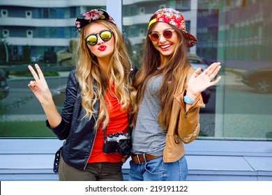 Bright stylish lifestyle urban portrait of two pretty best friends girls posing at leather jackets bright swag hats and sunglasses. Having faun, send you kiss and say hello. - Powered by Shutterstock