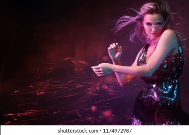 Bright And Stylish Young Woman Dancing In Club, Color Light, Motion Effects. Black Background, Long Exposure