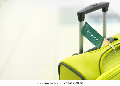 Bright Suitcase With Handle And Label Economy. Luggage At Airport. Modern And Elegant Bag For Travel. Object On White Background. Tag With Information On Baggage. Bag For Tourism And Vacation.