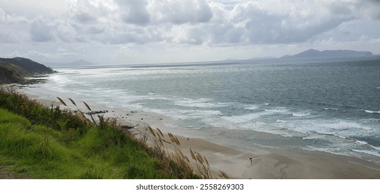 A bright summer day at the beach turns dramatic as dark storm clouds roll in over the horizon, contrasting the golden sand and turquoise water. - Powered by Shutterstock