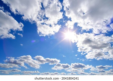 Bright, summer, sultry sun against background blue sky and white clouds
