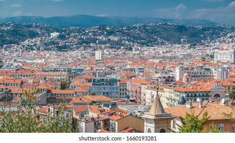 Bright sun lights red roofs of the old city timelapse. Aerial view from Shatto's hill. Mountains on background. Summer day. Nice, France