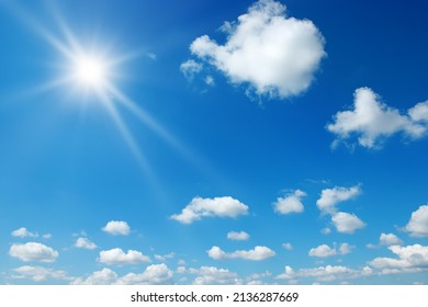 Bright sun on beautiful blue sky with white fluffy clouds. - Shutterstock ID 2136287669