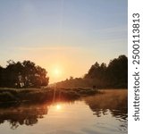 bright sun over the river. fisherman on the river bank. landscape in summer. fog over the water. nature of Europe 