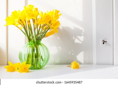bright sunlight shines on Easter bells, daffodils flowers in vase on the windowsill. country style bouquet for spring decoration or Easter decoration against open background with copy space