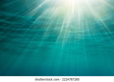 Bright sunlight streaming in deep idyllic blue seascape during sunny day