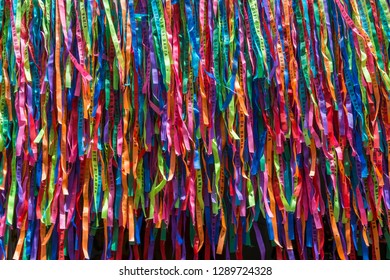 Bright sunny full frame background of a wall of colorful Brazilian wish ribbons in an abstract close-up