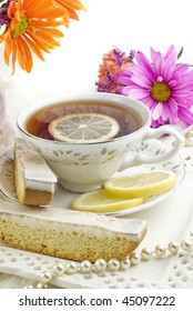 A Bright Sunny Ladies Tea Party With Fresh Flowers, Cup Of Tea, With Fresh Lemon Slices On Fine China With Lemon Biscotti Cookies, Vertical With Copy Space, Perfect For Mother's Day