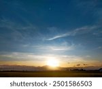 Bright Sunrise: A natural scene showing the sun rising with bright and golden rays under a blue sky.