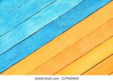 Bright two-tone background from wooden textured planks. Wooden planks painted in blue and orange are arranged diagonally and separated into two parts. Painted textured wooden background. Stock fotografie
