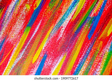 Bright variegated multicolored background of brush strokes with different paint close-up. Art and creativity backdrop. Red, yellow, blue, orange, pink paint strokes. Art and drawing concept. Abstract