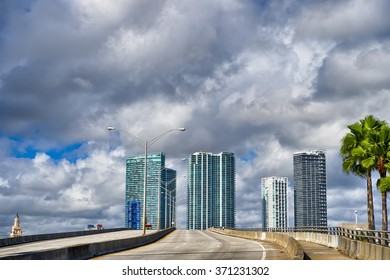 Bright View Of Exotic Beautiful Of Miami Highway Grey Road With Green Palm Trees Sky Scrapers No People And Cars In Sunny Weather Outdoor On Natural Grey Cloudy Sky Background, Horizontal Picture