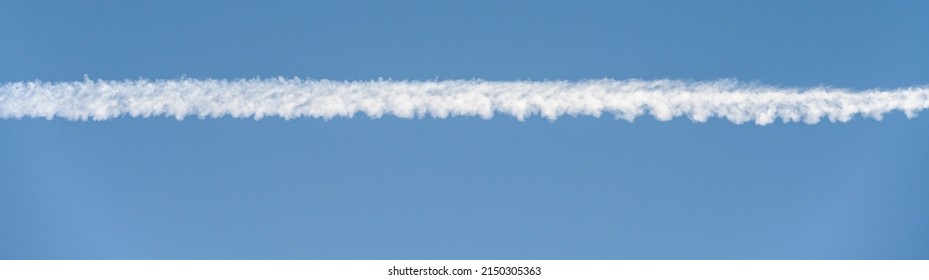 Bright White Contrail Cloud Against A Clear Blue Sky, As A Graphic Background
