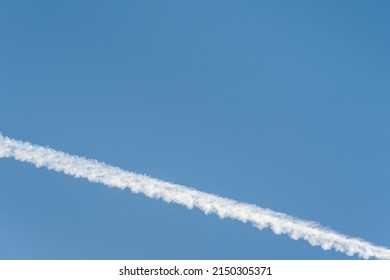 Bright White Contrail Cloud Against A Clear Blue Sky, As A Graphic Background
