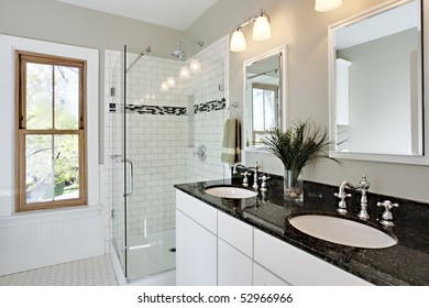 Bright white remodel bathroom. Glass shower and granite counters.