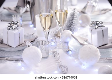 bright white and silver new year eve or christmas table in a luxury restaurant with champagne
