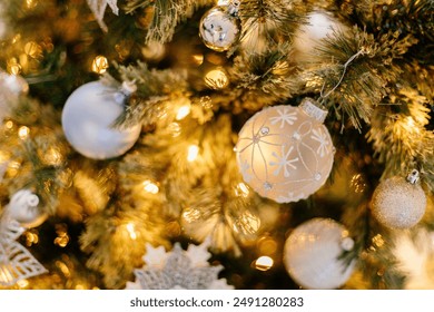 Bright white and silver ornamernts on Christmas tree against a background of bokeh of Christmas lights. New Year, Christmas background. Christmas tree, boxes with gifts,New year's figurines and decor - Powered by Shutterstock