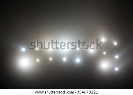 Bright white and yellow Stadium lights with fog. Defocused image 